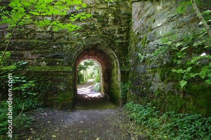 brick archway into forest path